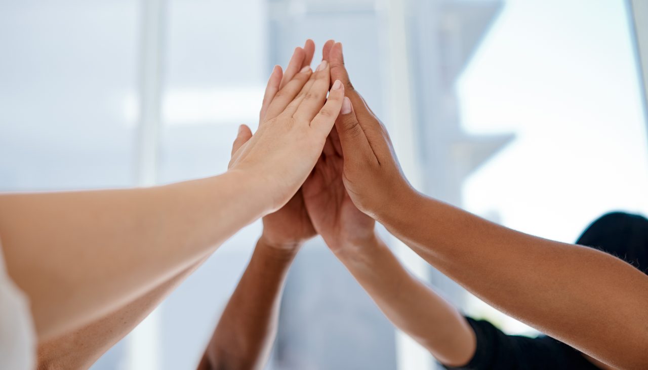 Diverse Team Success High Five Diverse hands joining together in a huddle to represent community collaboration and child care advocacy.