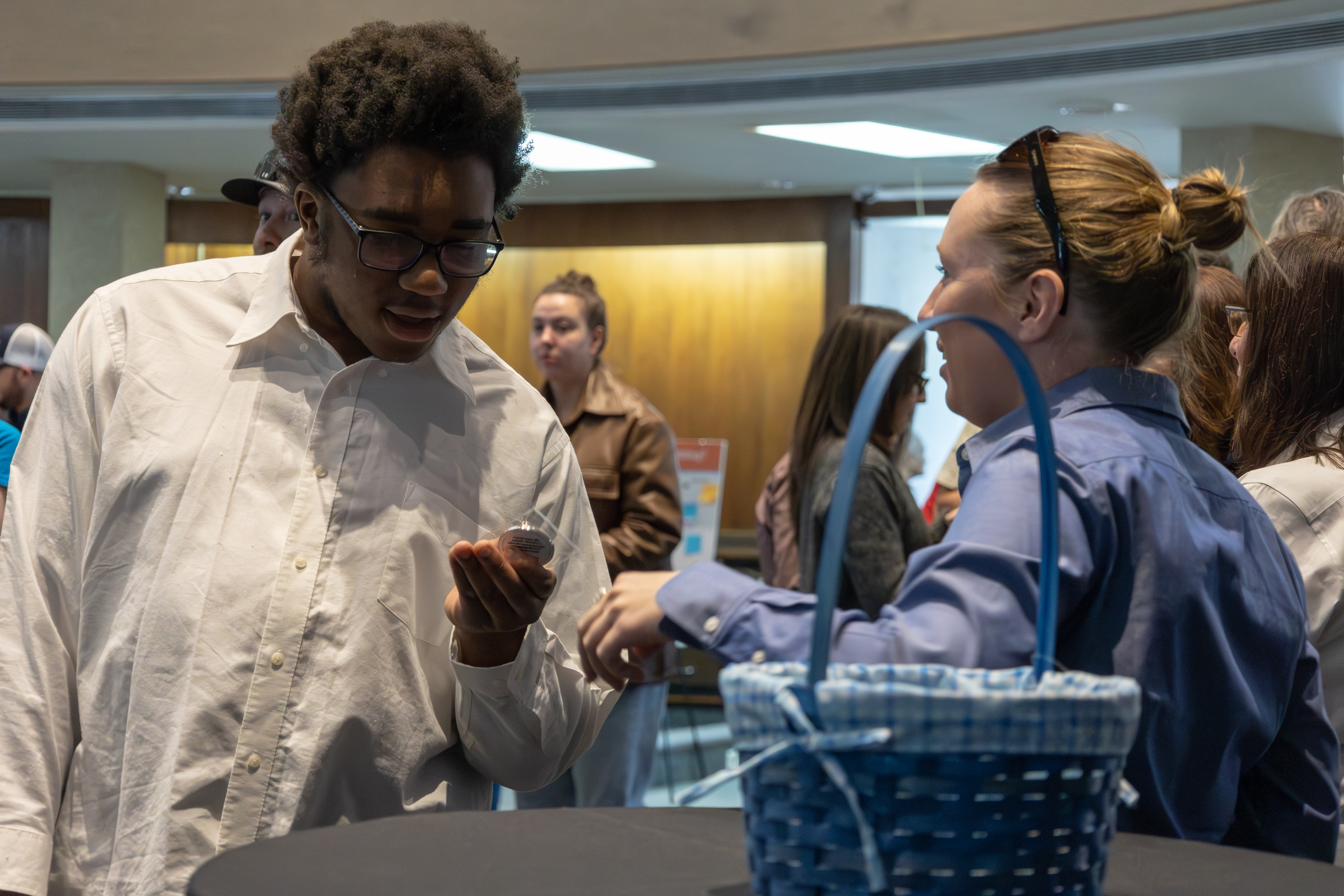 Attendee views commemorative coin being handed out.