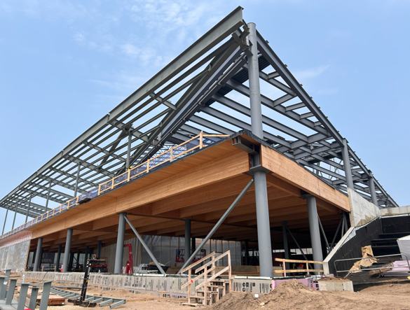 Looking northwest, first floor exposed wood beams and second floor steel beams visible before exterior is completed