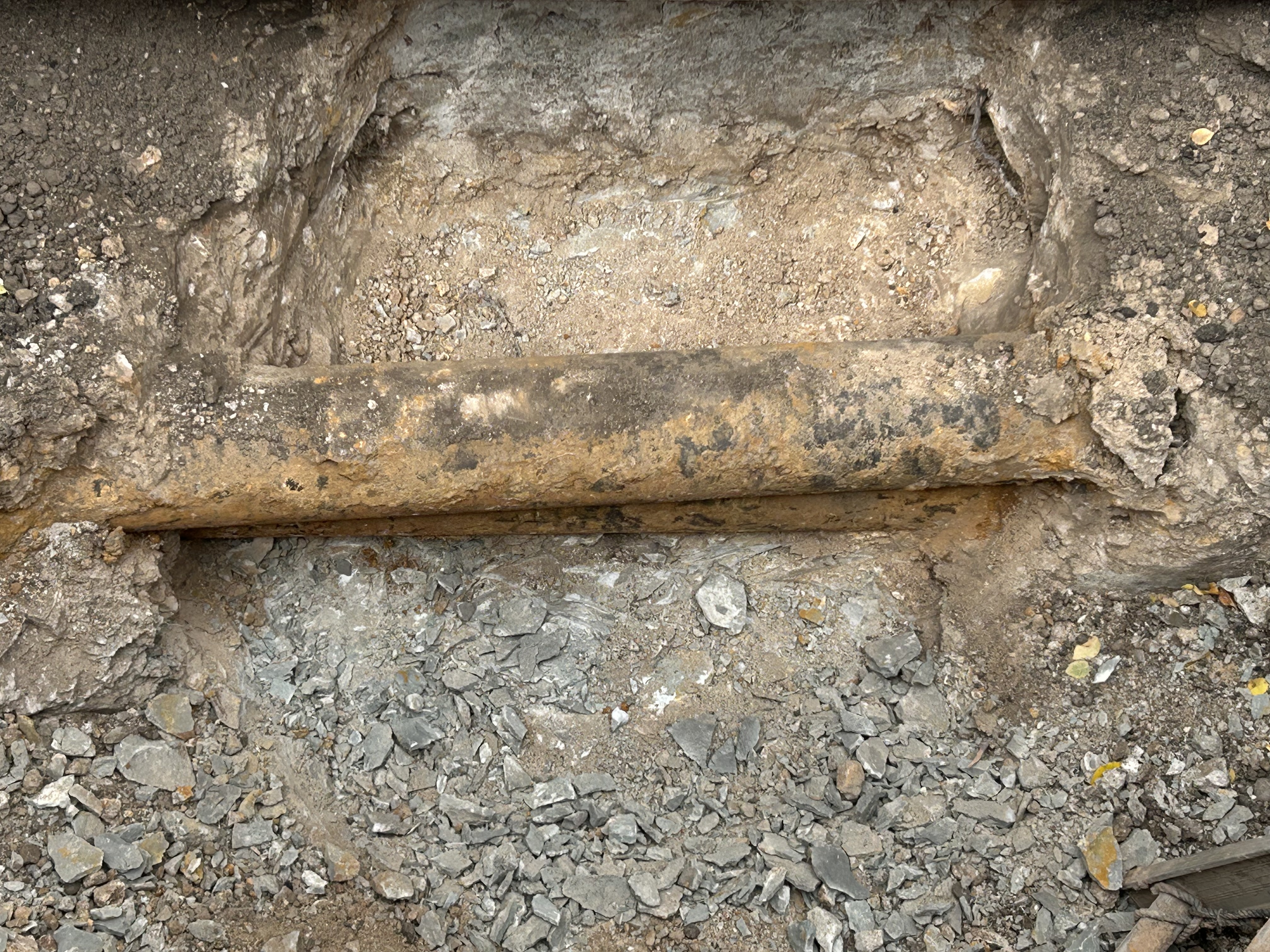 Looking into a hold with old pipeline laid directly above another pipeline. 