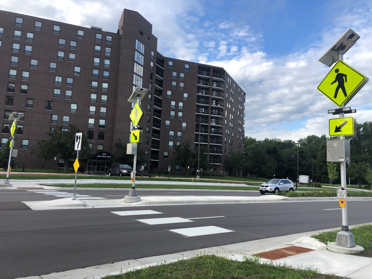 A crosswalk with pedestrian signs and push buttons