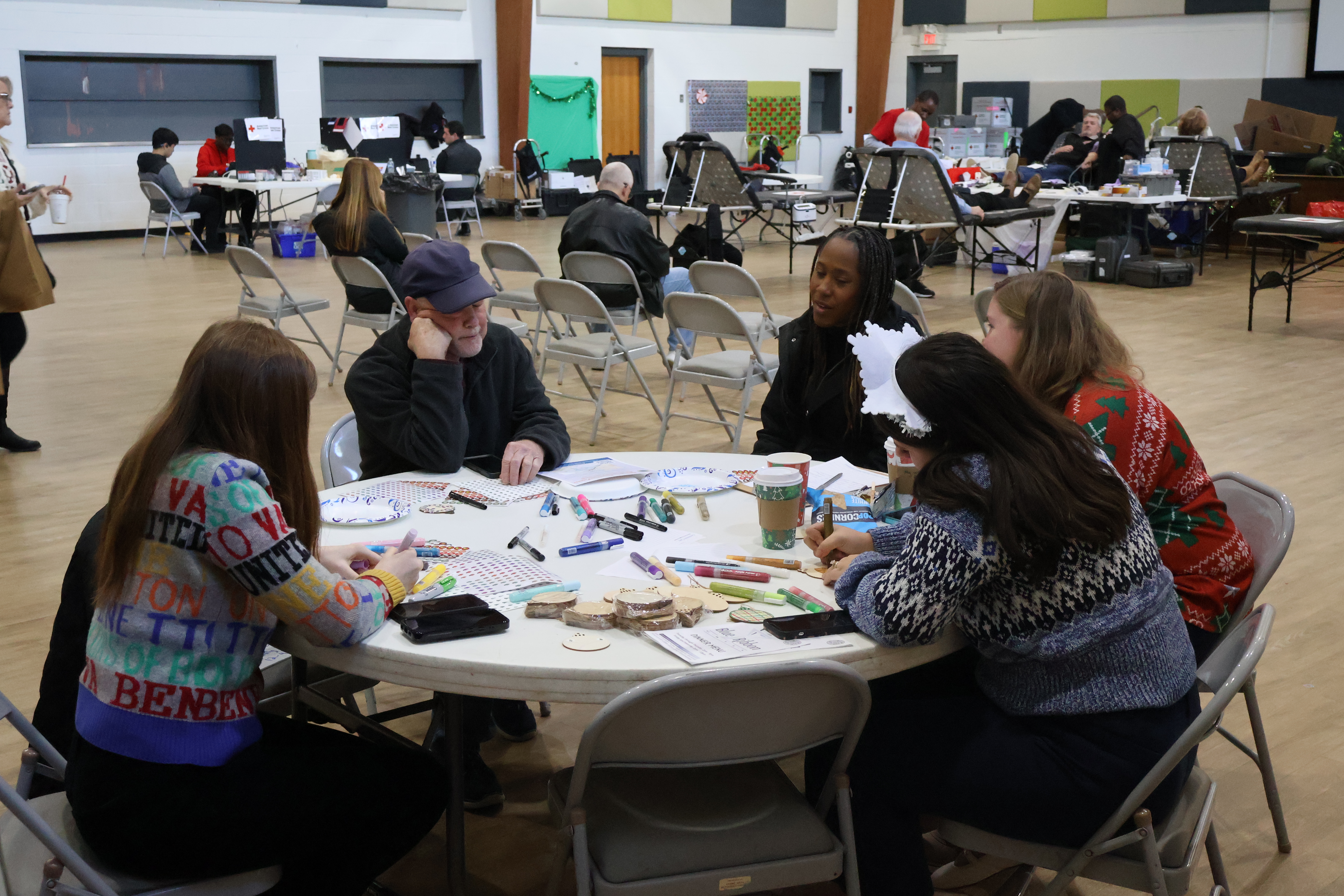 Group of people at a community meeting looking over information on a table.