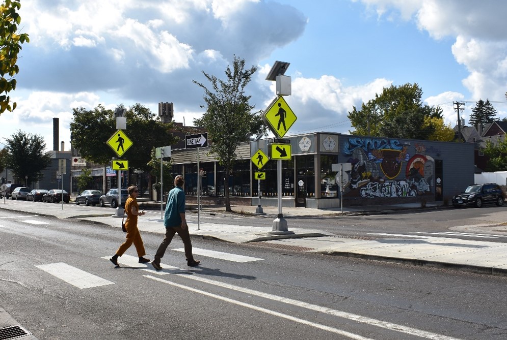 Two people walking across a road in the crosswalk