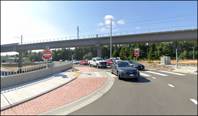  An image showing a sidewalk, a truck apron with red, patterned concrete that accommodates large turning vehicles