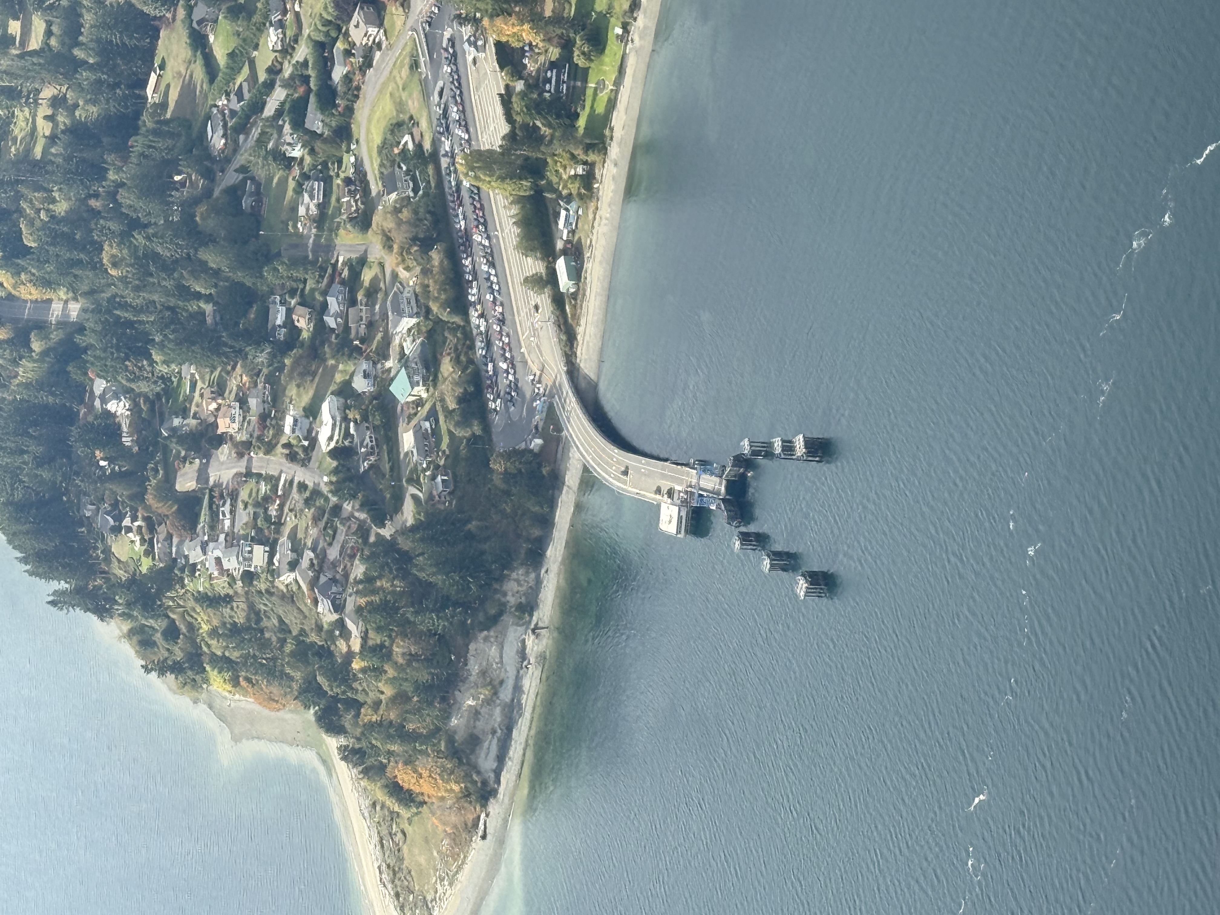 An aerial view of the entire terminal area including the terminal building, docking structures and parking lot from a distance.