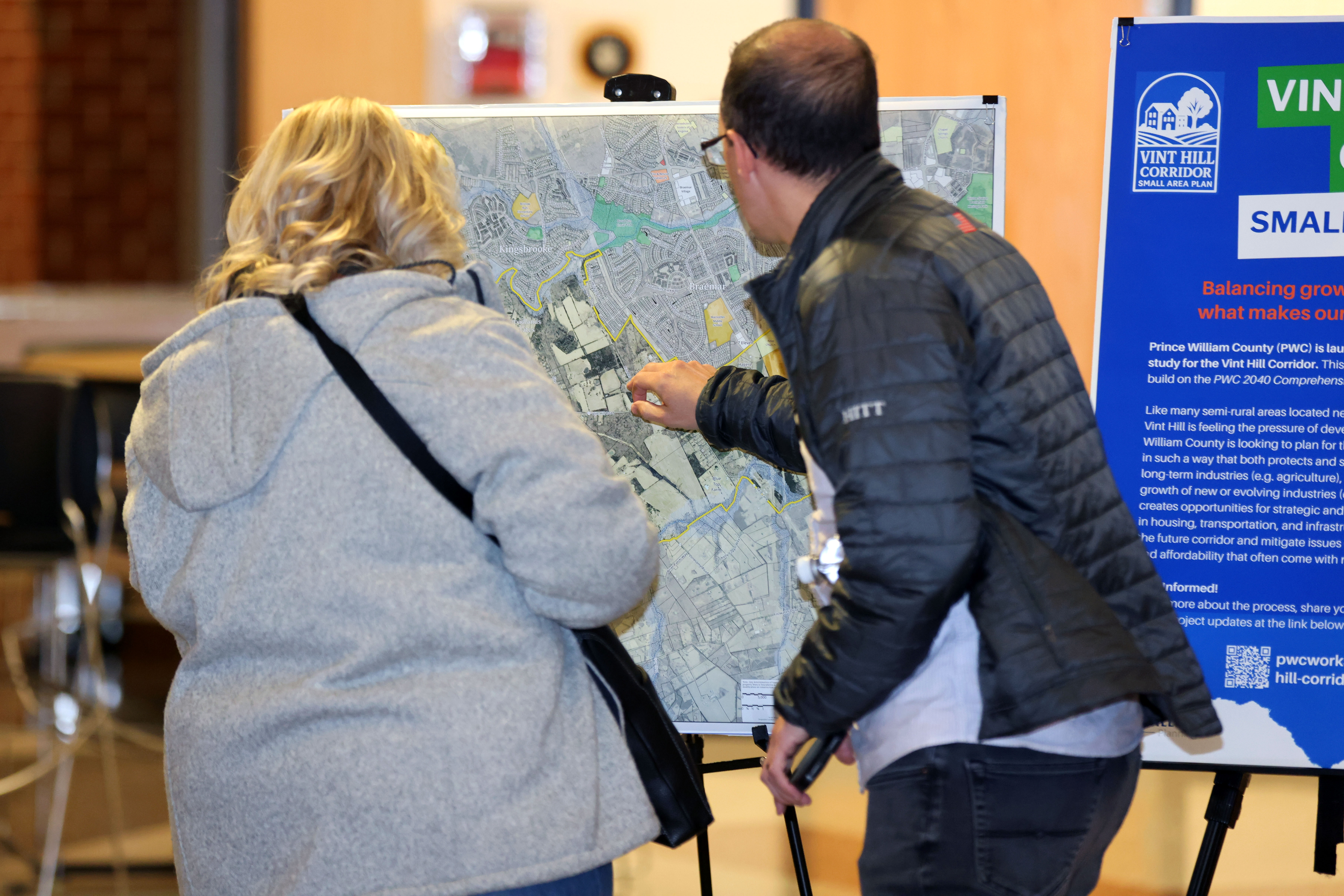 People at pubic meeting looking at a poster