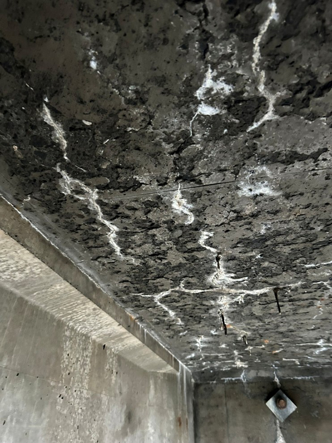 From January 2026 inspection, the concrete has deteriorated through the bridge deck, risking debris falling onto lanes of Interstate 90 below.