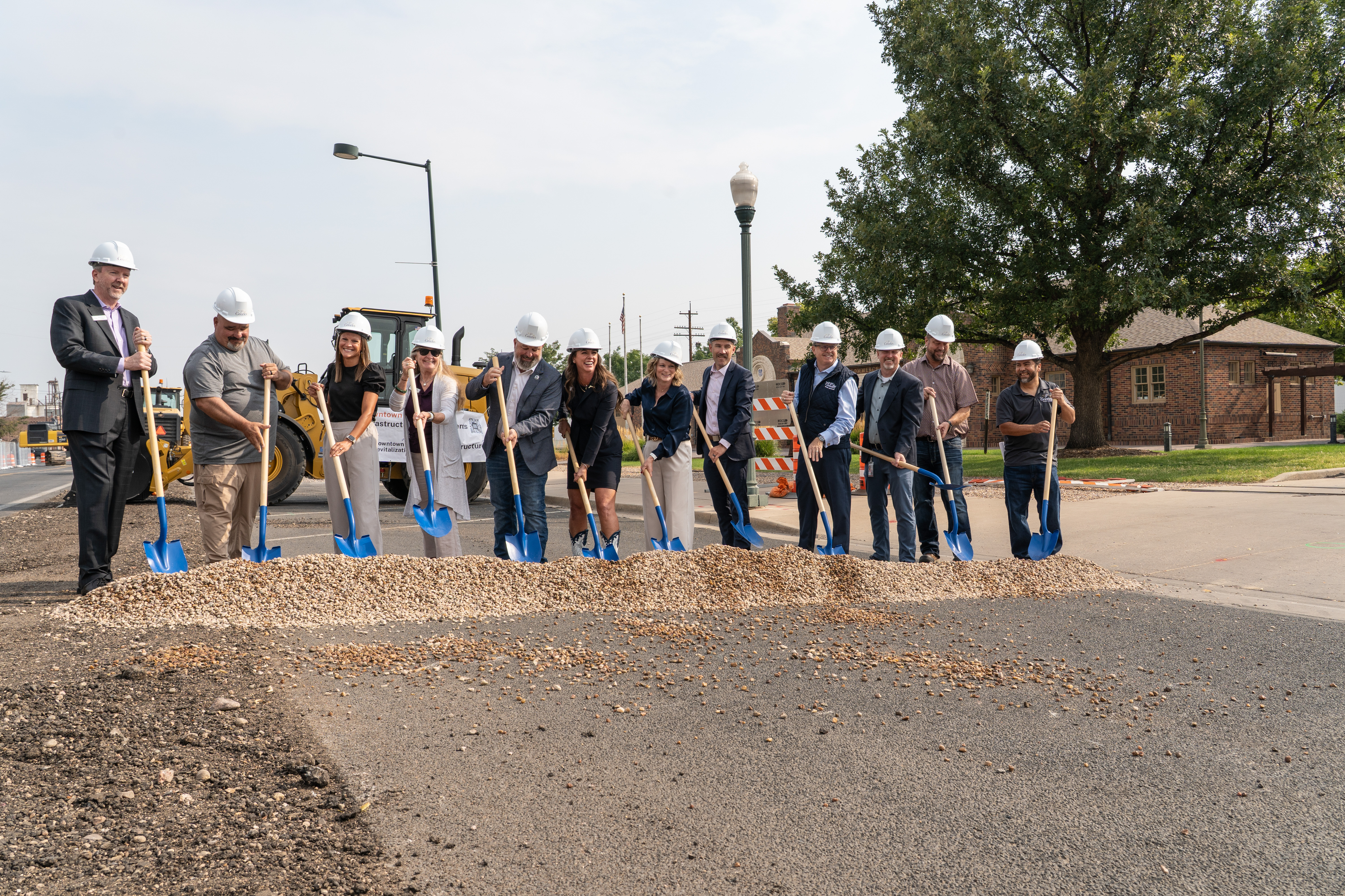 City leaders and project staff break ground on the project wearing hard hats and with shovels.