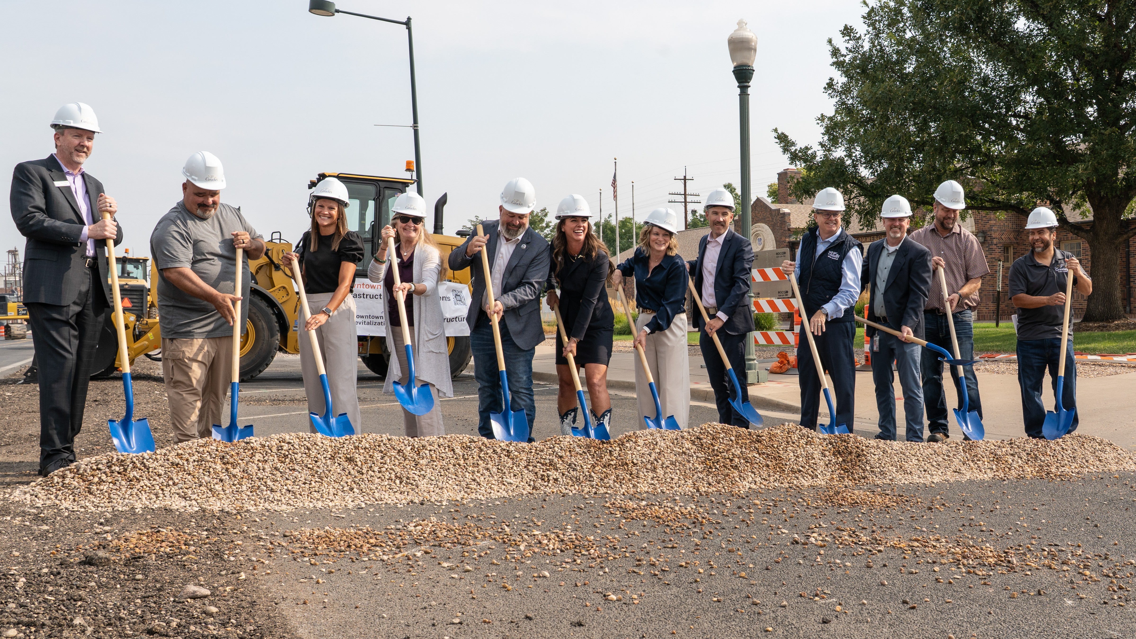 City leaders and project staff break ground on the project wearing hard hats and with shovels.