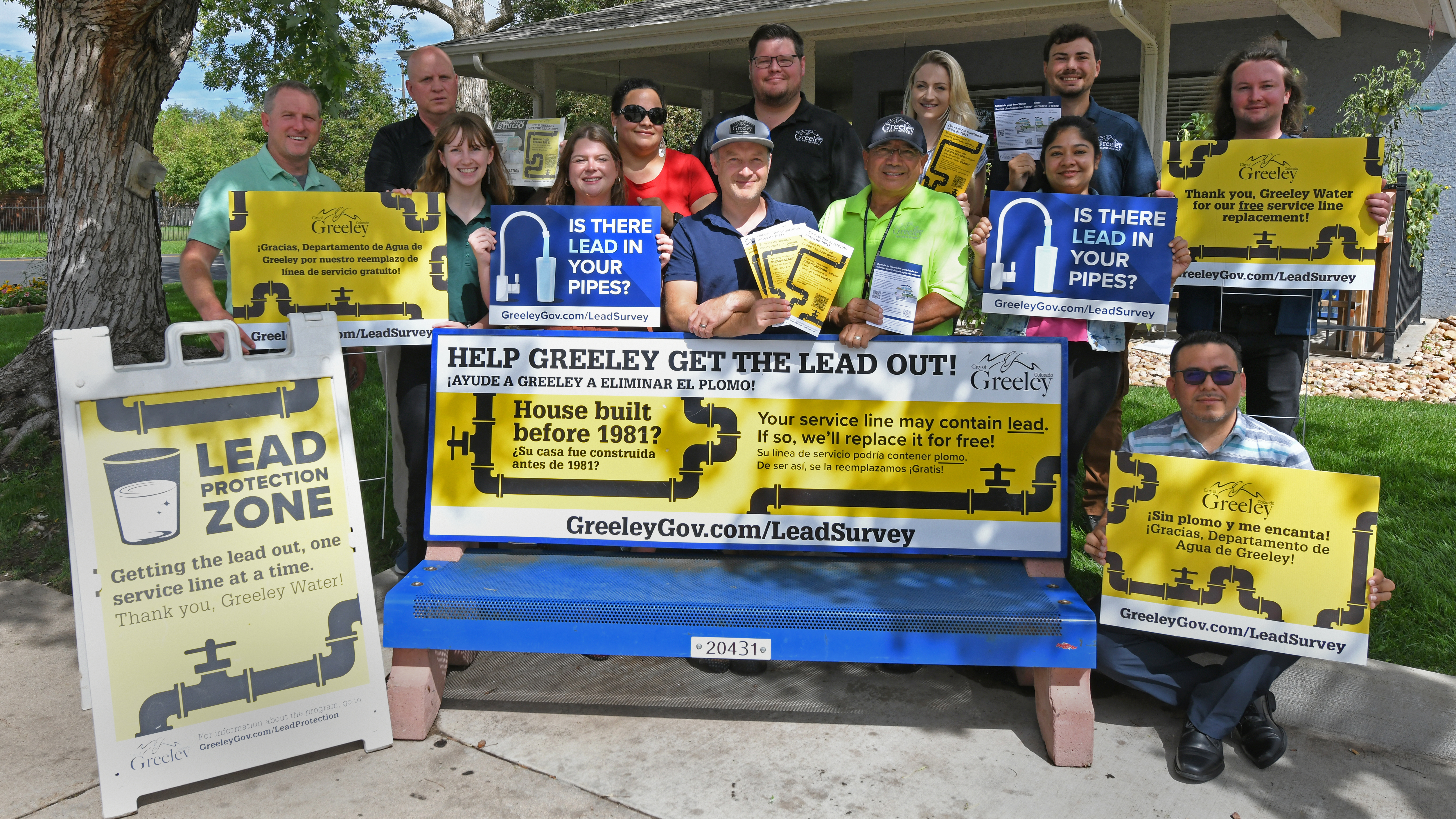 Members of Greeley's Lead Protection Program Team stand behind a bus bench to show off the materials used to promote the project.