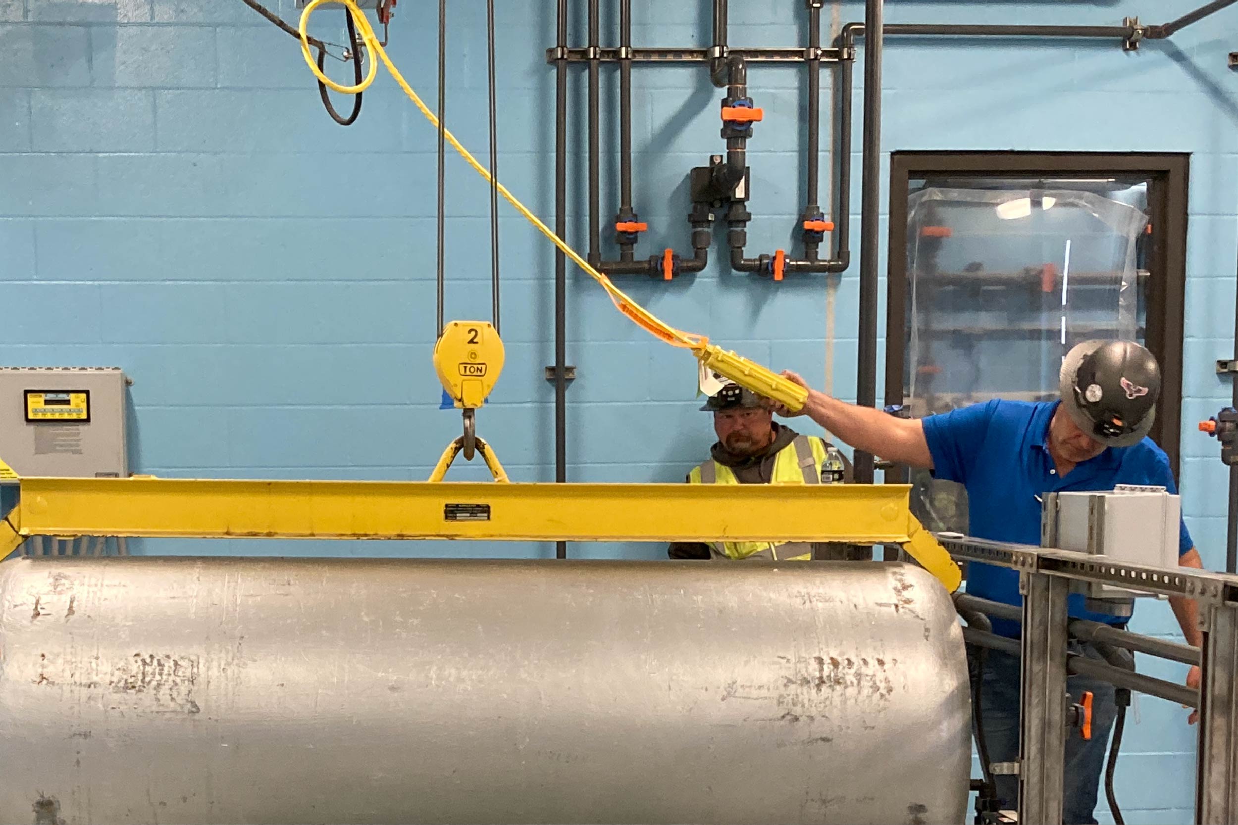 City of Columbia staff members lower an empty chlorine tank into position while testing the new jib crane in the Chemical Building.