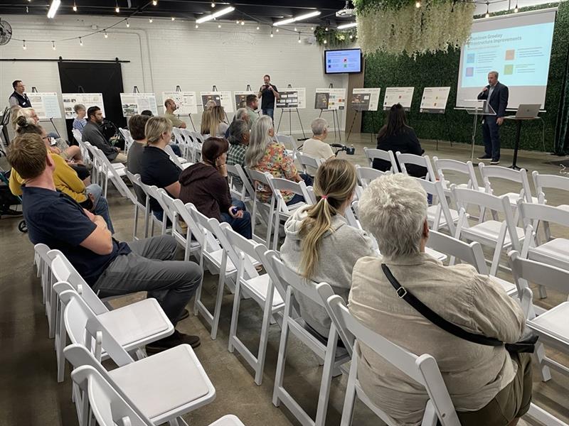 Open house attendees listen to a presenter