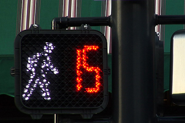 A pedestrian signal displays a countdown timer, letting people know how much time they have left to cross the street safely.