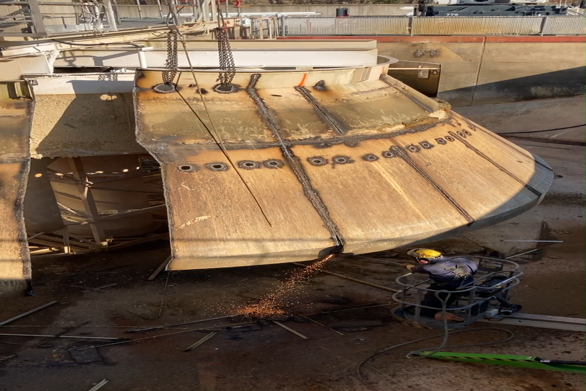 A worker cuts through a panel of the cone in the clarifier on Primary Basin 1. 