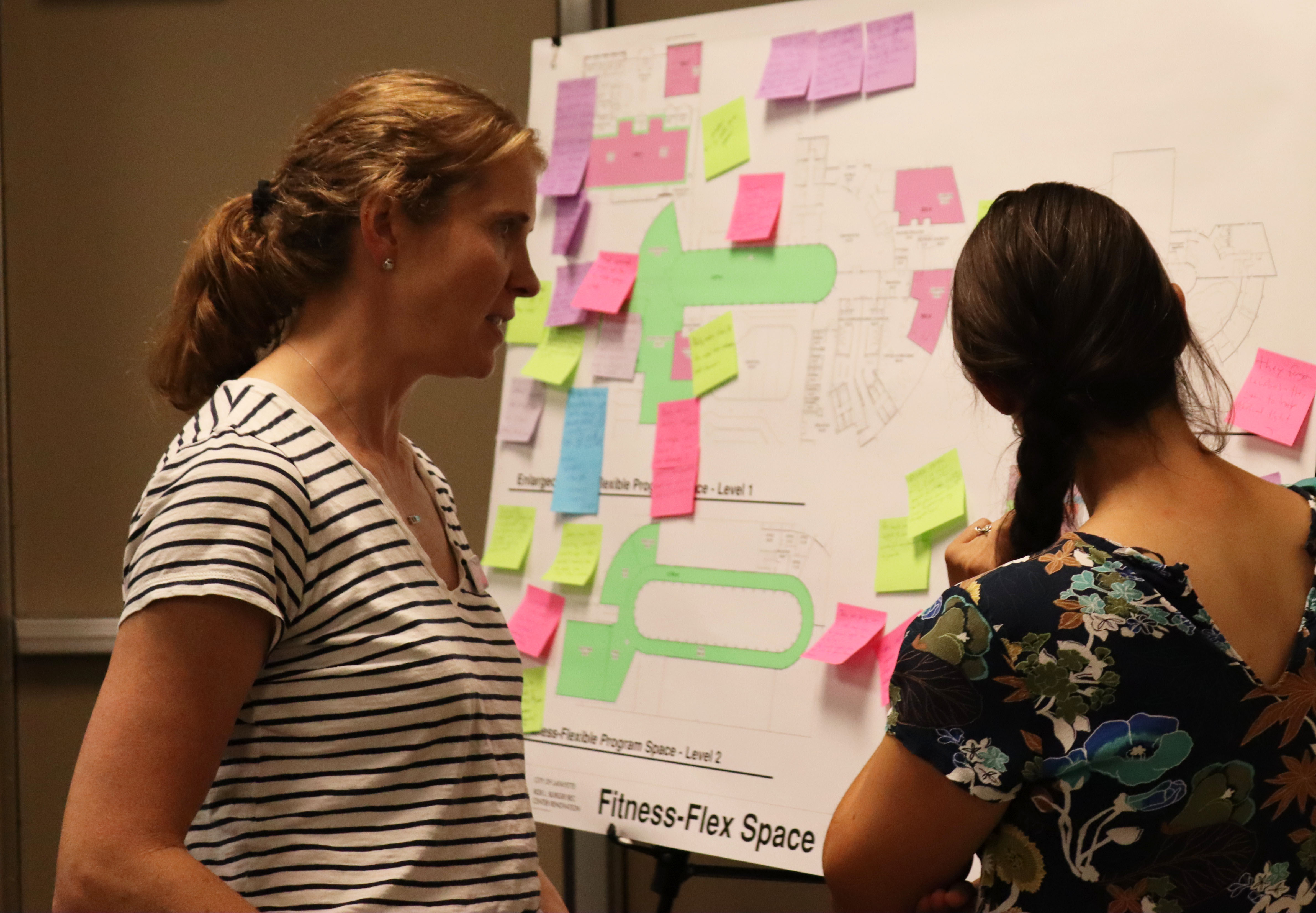 Fitness Supervisor Lexi Bulich discusses flexible fitness spaces with a community member at the August 22 event.