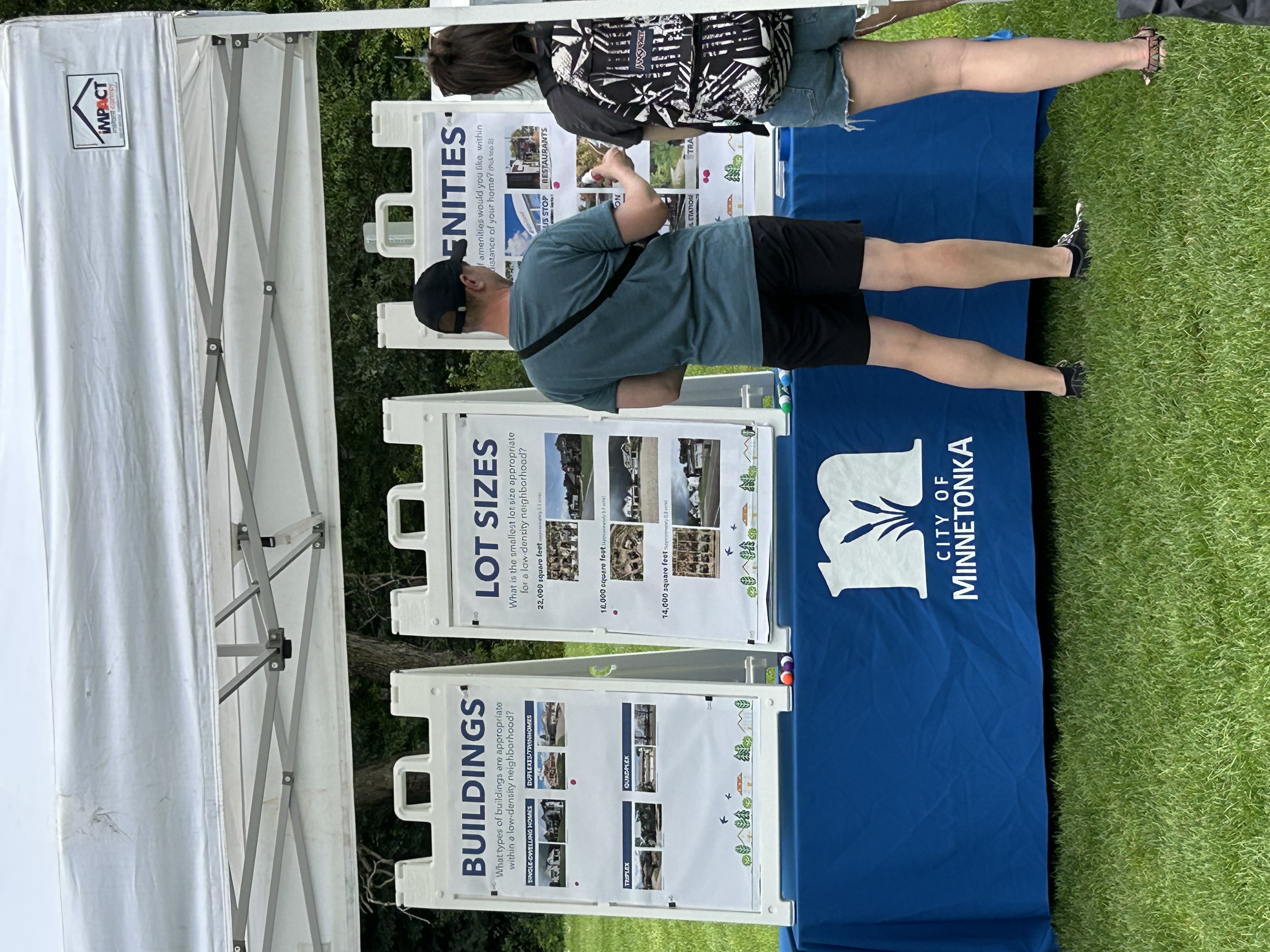 Person standing in front of three white boards on a blue tablecloth