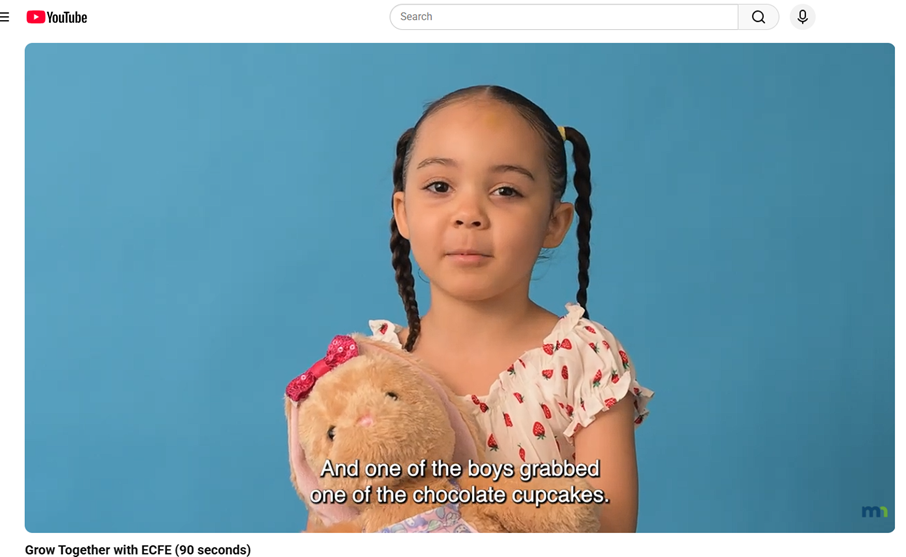 Little girl holding a stuffed bunny from the video