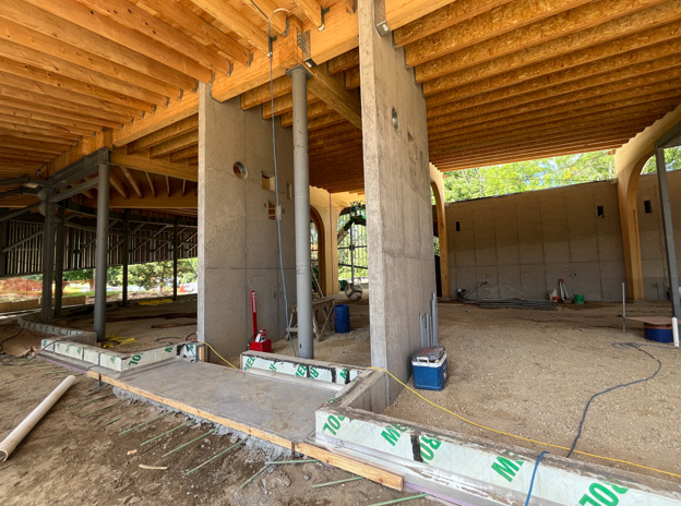 Two vertical concrete walls at the edge of a large room serving as the staff entrance to the building.