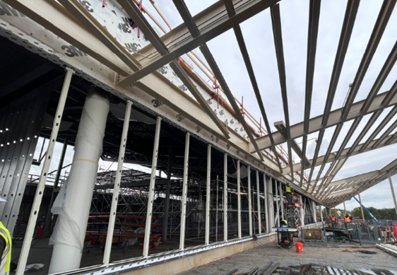 Image shows new construction, framed wall on left side, slanted overhanging framed roof at top of image