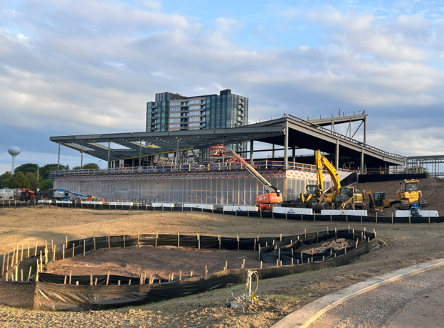 Image shows black fence and earthwork at the foreground, and new Southdale Library building structure in the background.