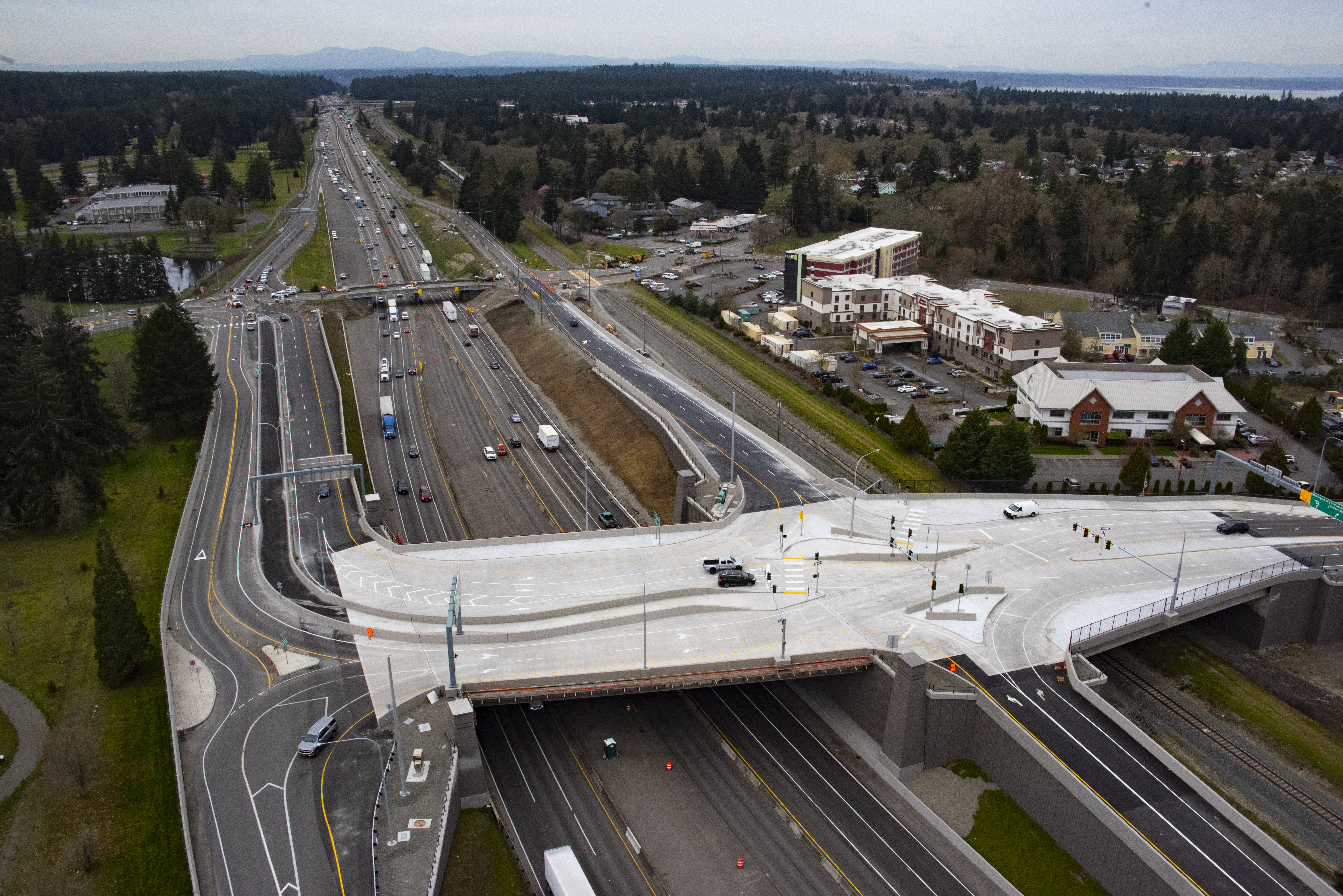 Aerial photo showing the rebuilt I‑5 Steilacoom‑DuPont Road interchange with new overpass, roundabout and ramps connecting JBLM and nearby communities.