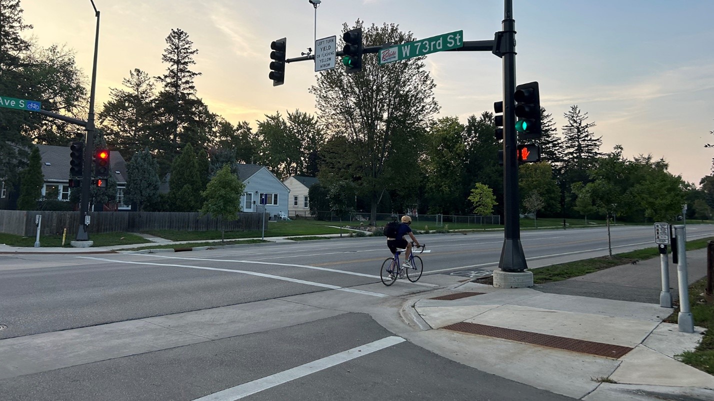An intersection with a biker traveling on an on-street bike lane