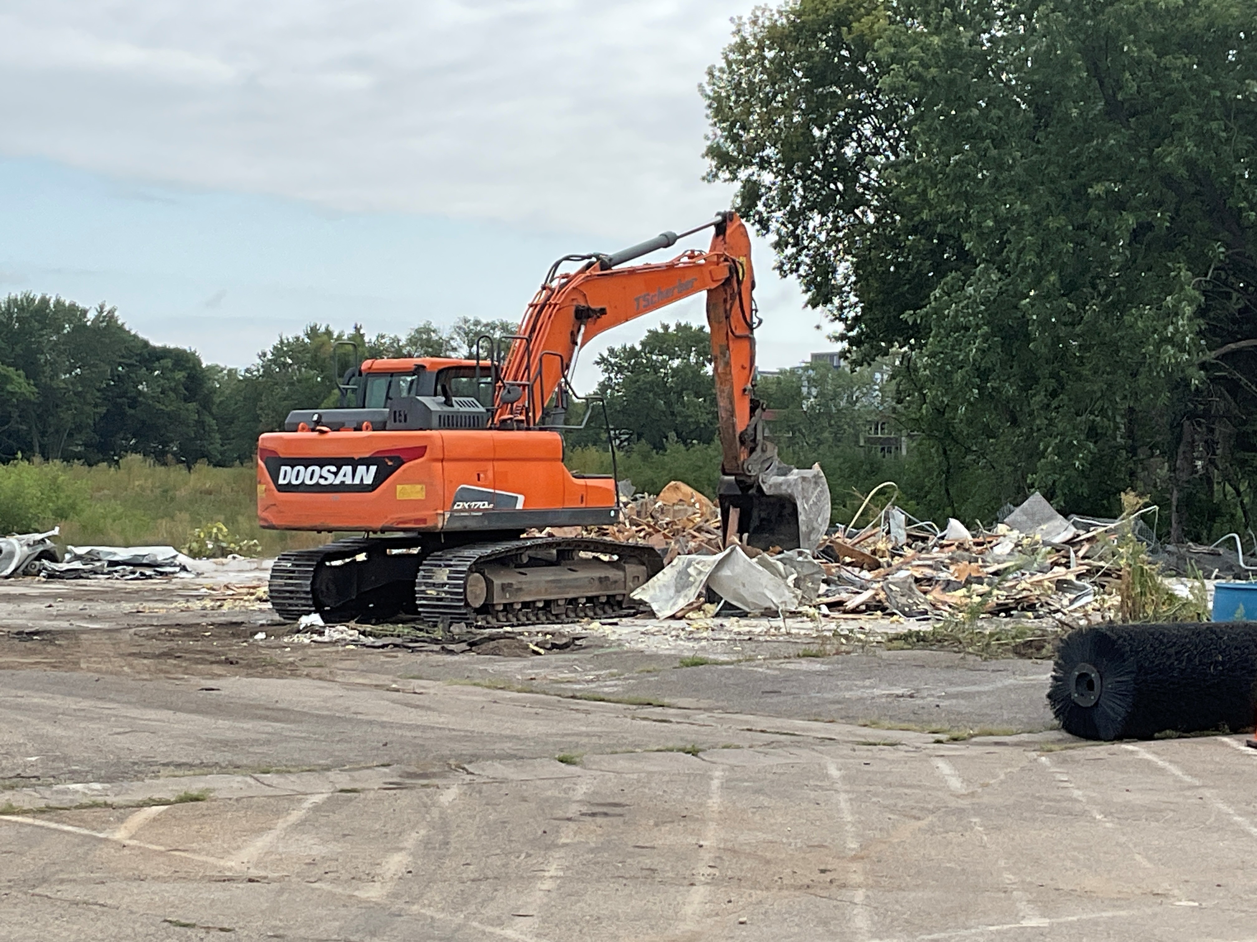 Excavator removing maintenance building