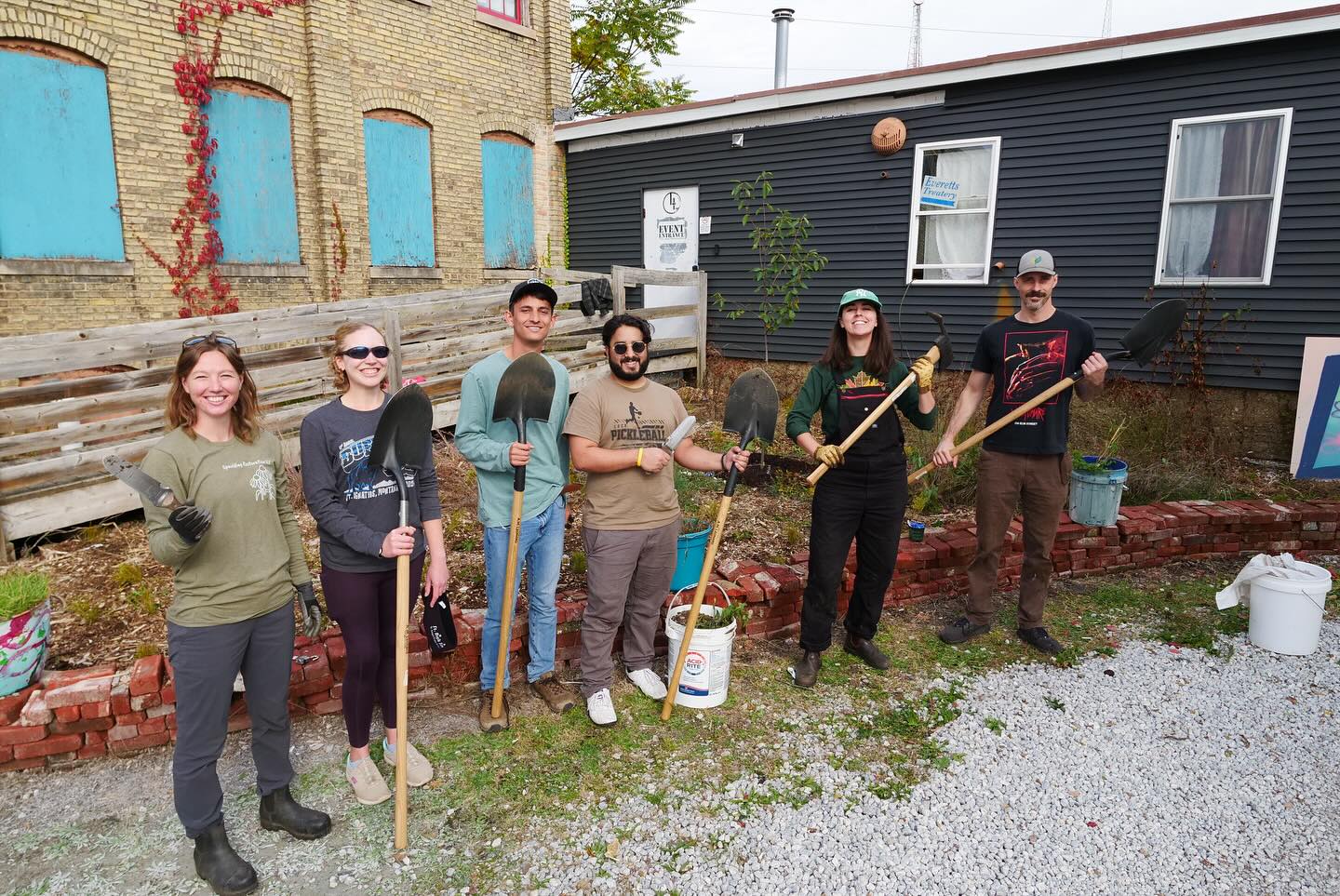 6 people who just planted a tree posing together.