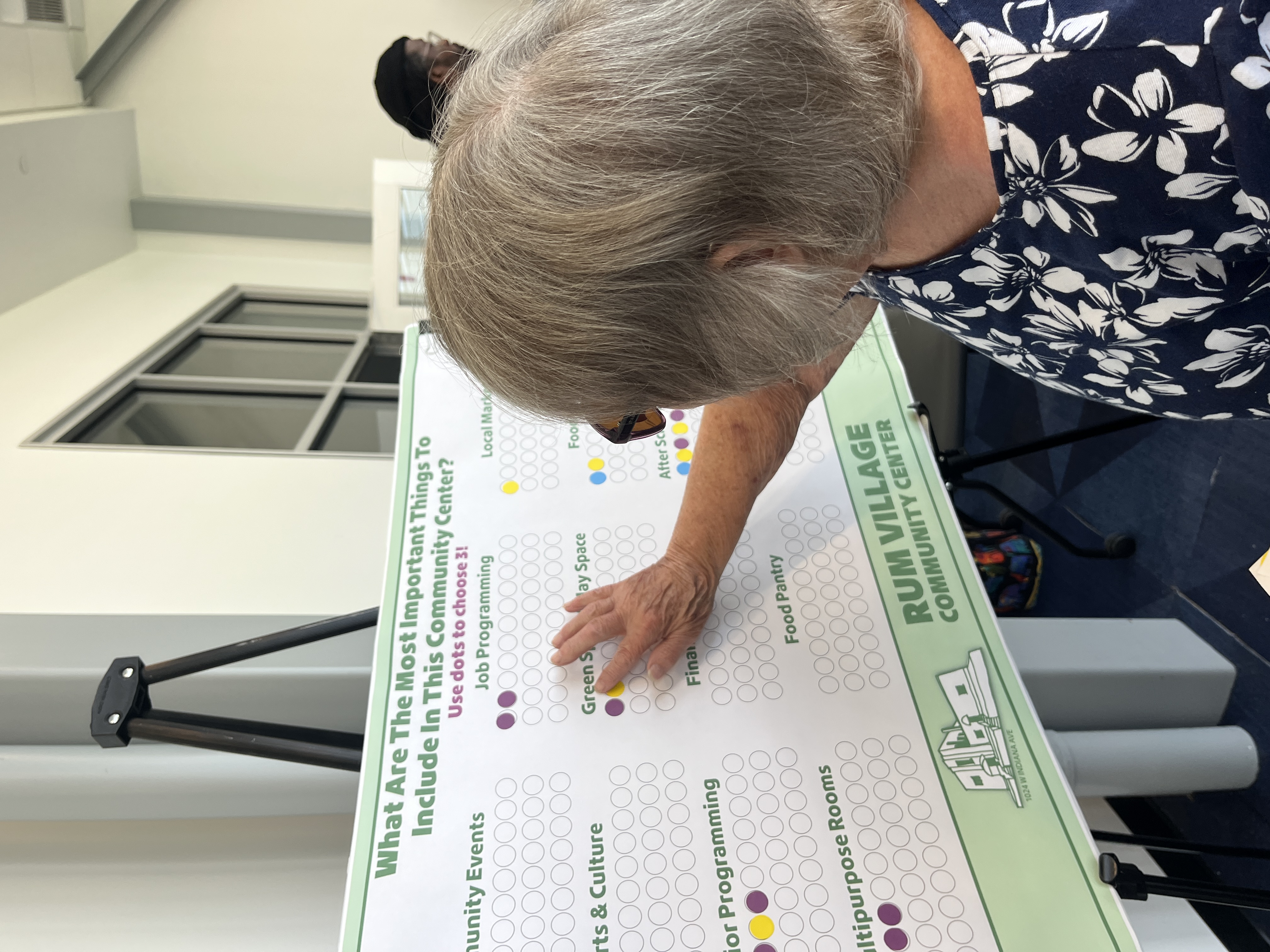 woman voting for green space as an important thing to include at the Rum Village Community Center