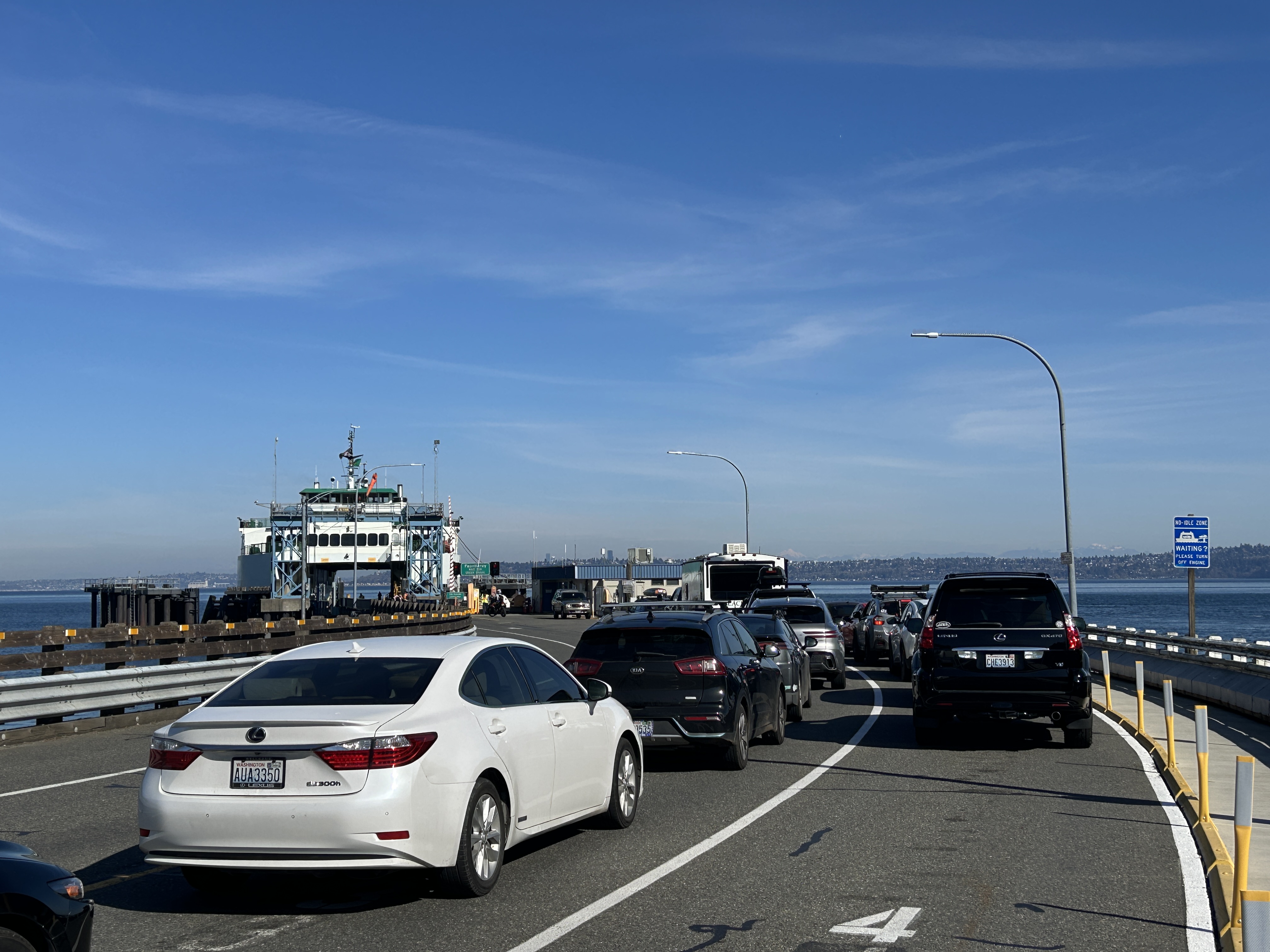 A line of cars on the dock ready to load onto the waiting ferry.