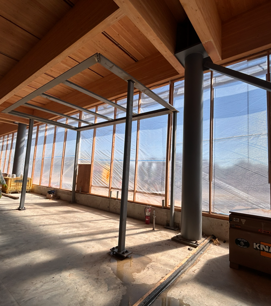 Steel rectangular framed structure inside the library, set off slightly from the exterior wall and sits just below the ceiling.