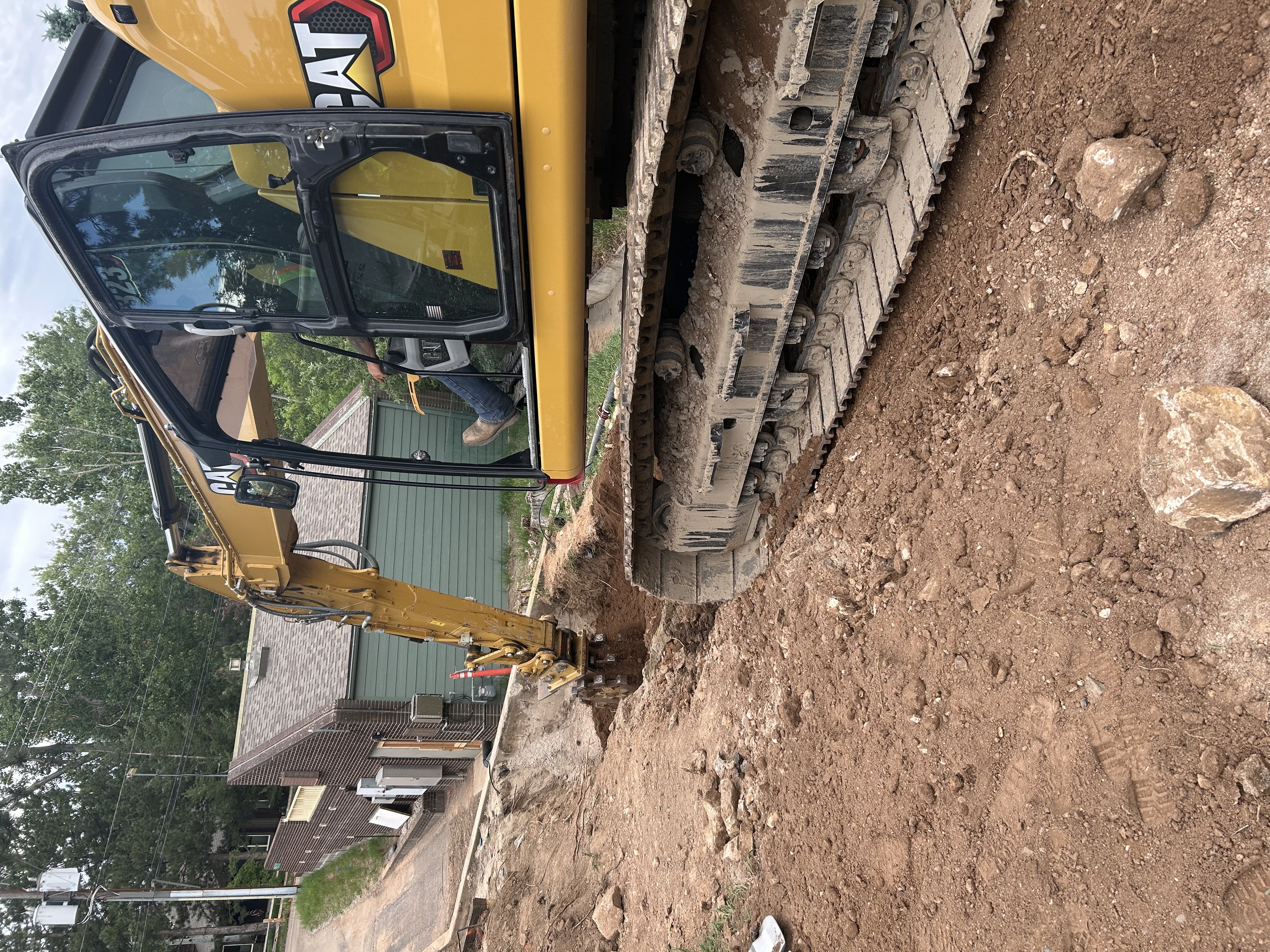 Heavy equipment shown digging along roadway.