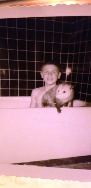 Gene, age 15, with pet possum, Booger. 1956