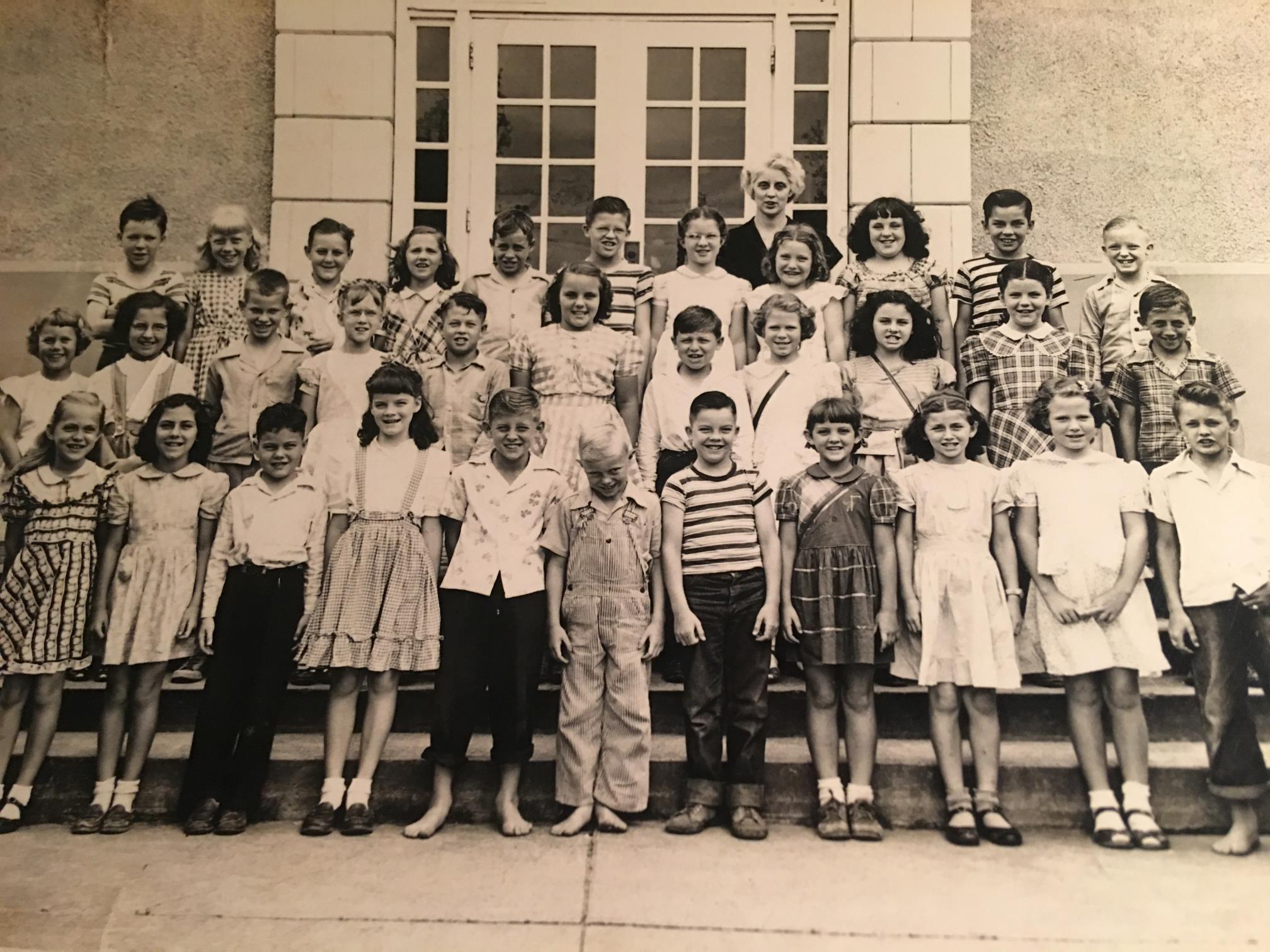 Gene is in the 2nd row, behind the boy in the striped shirt.