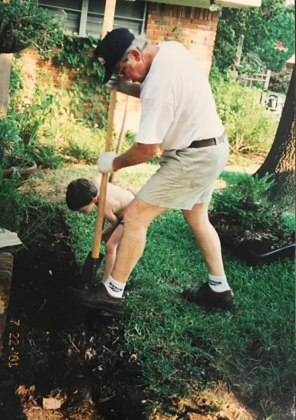 Creating yet another flower bed, this time with the help of grandson Mason. July 2001