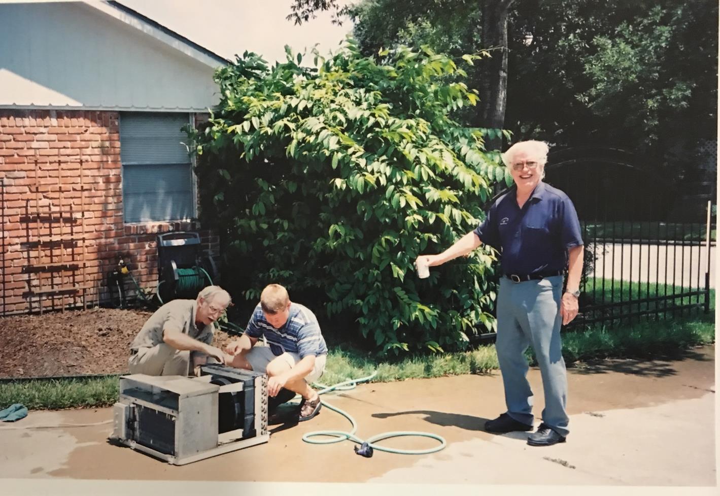 Kevin and Gene fix an air conditioner, with supervision from Mark Fox, 2003