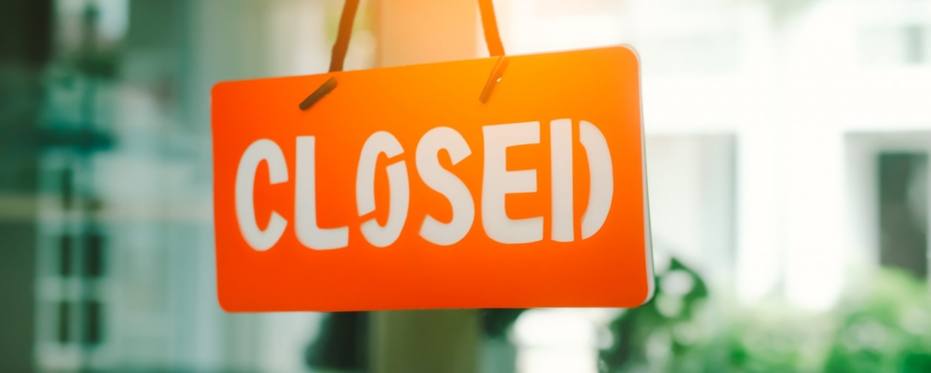 A closed sign hanging in the window of a store