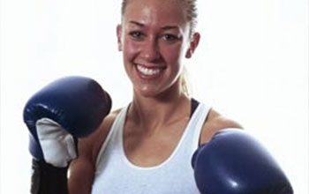 Accomplishments - Muay Thai Fighter Laura wearing boxing gloves.