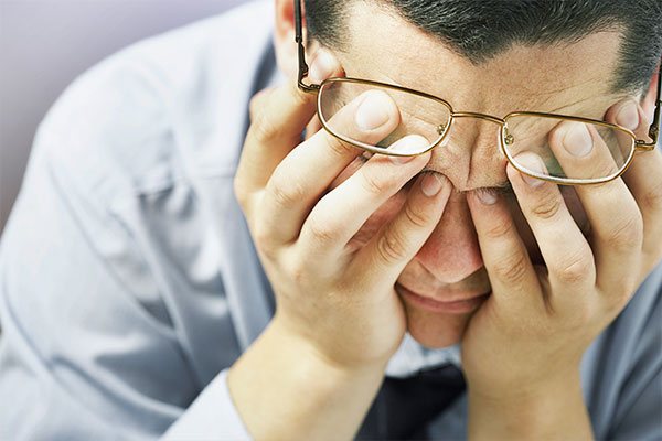 Photo of a man with his head in his hands