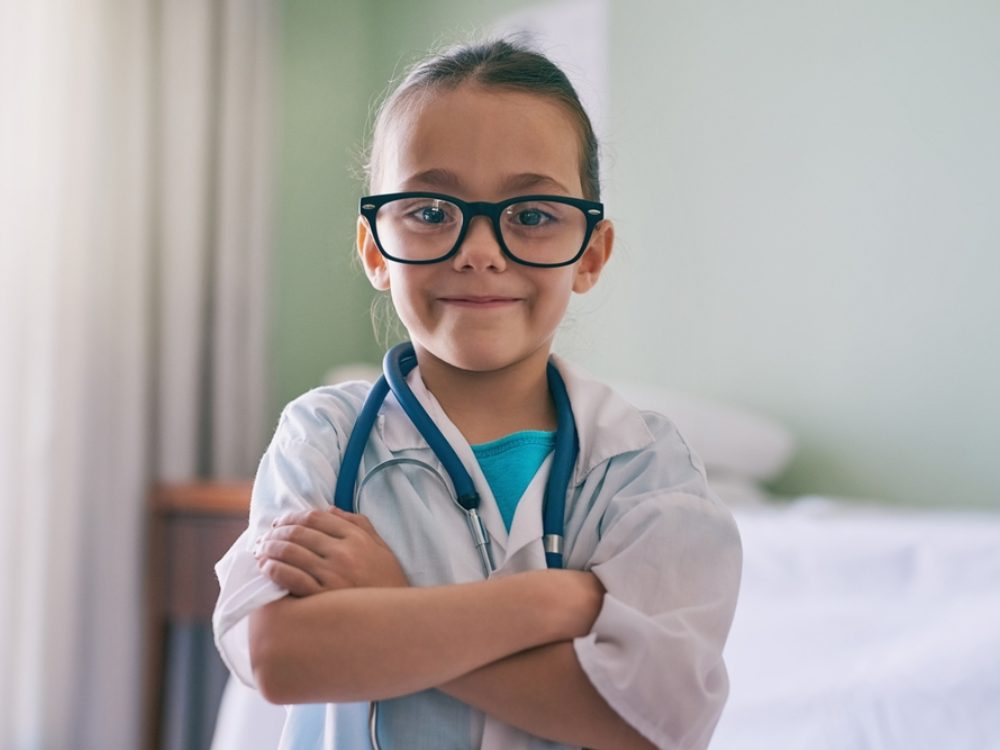 Young girl in glasses and doctor's uniform