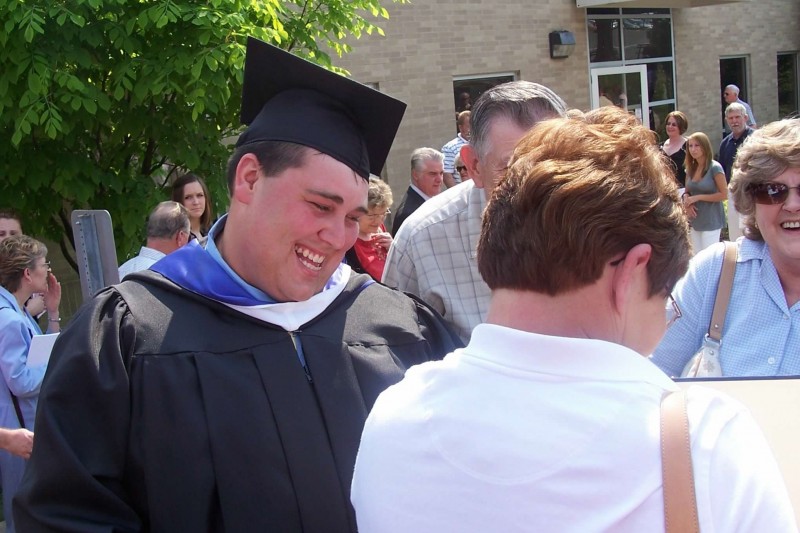 Nick's graduation with family checking out his diploma