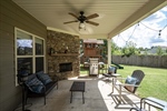 Covered rear patio with a wood burning fireplace