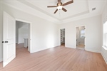 Huge primary suite with tray ceiling and fan.