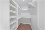 Walk in closet with built in shelving.