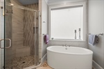 Sleek vessel tub adjacent to shower