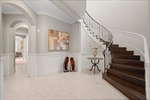 Gorgeous curved stairway in paneled foyer