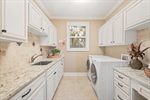 Spacious laundry room with built ins and sink.
