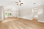 Great room with vaulted ceiling and lighted fan.