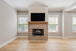 Beautiful fireplace flanked by windows.