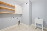 Main level laundry with utility sink and shelving.